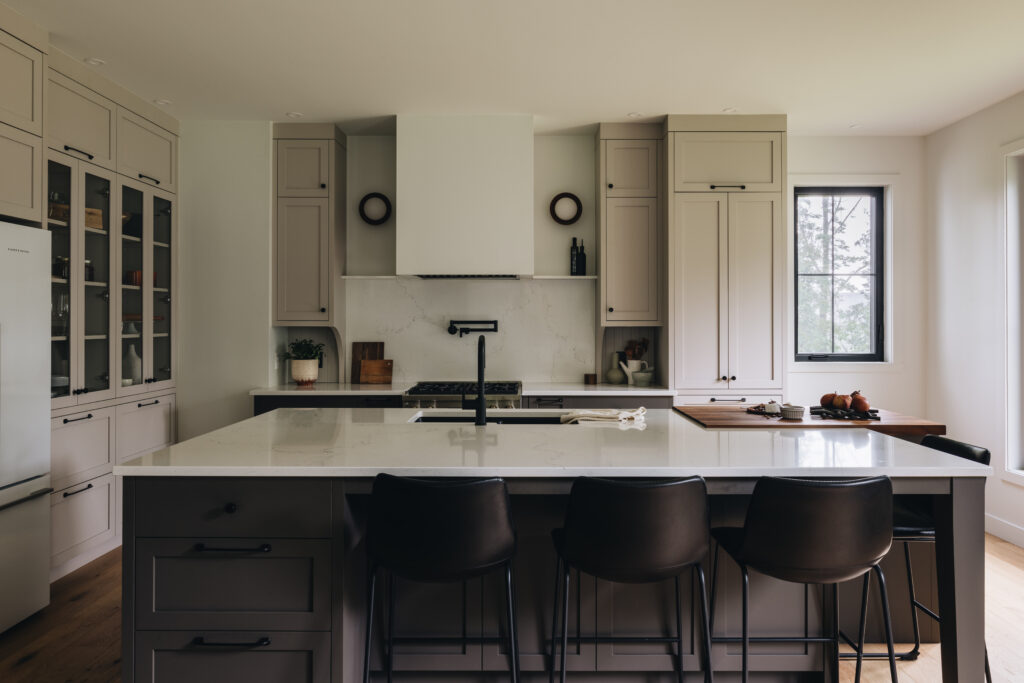 Cuisine transitionnelle sur mesure avec armoires grège, îlot central, bloc de boucher en noyer massif et design élégant