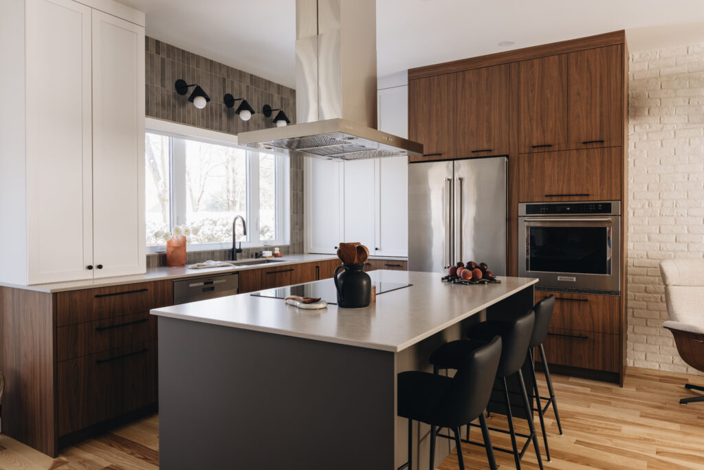 Cuisine contemporaine sur mesure avec îlot central, armoires en bois foncé, électroménagers encastrés et design chaleureux