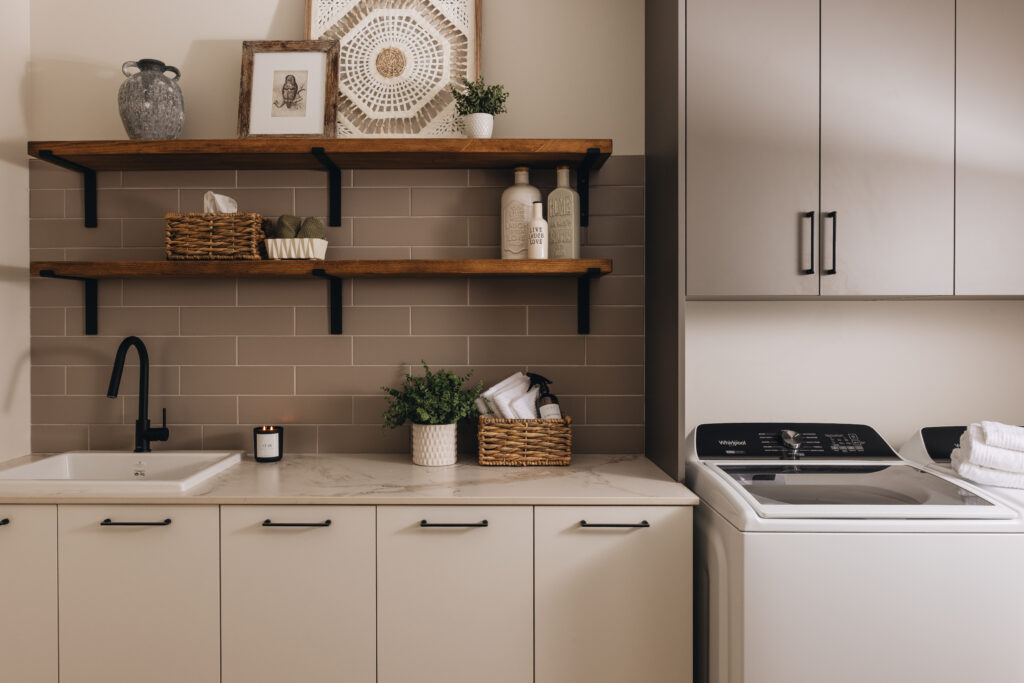 Buanderie sur mesure avec armoires claires, rangement intégré, étagères en bois et ambiance douce et apaisante