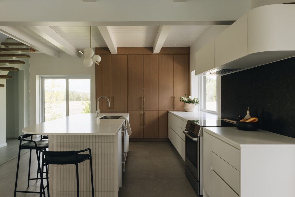 Cuisine élégante sur mesure avec îlot aux courbes douces, placage de chêne, comptoir mat et design contemporain raffiné