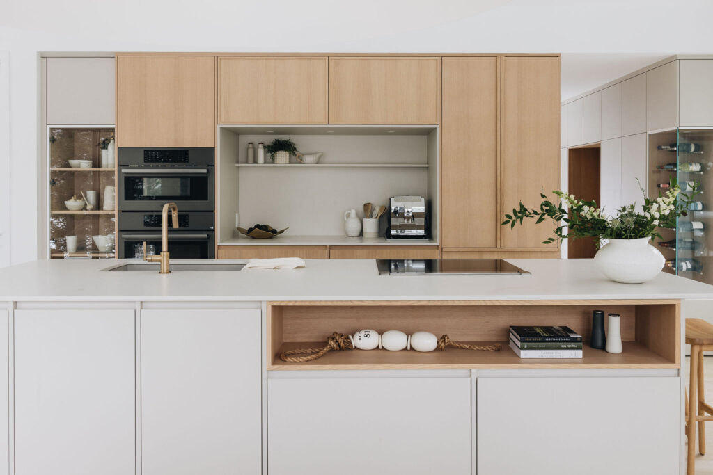 Cuisine minimaliste sur mesure avec armoires en bois clair et blanc mat, îlot central et design contemporain épuré