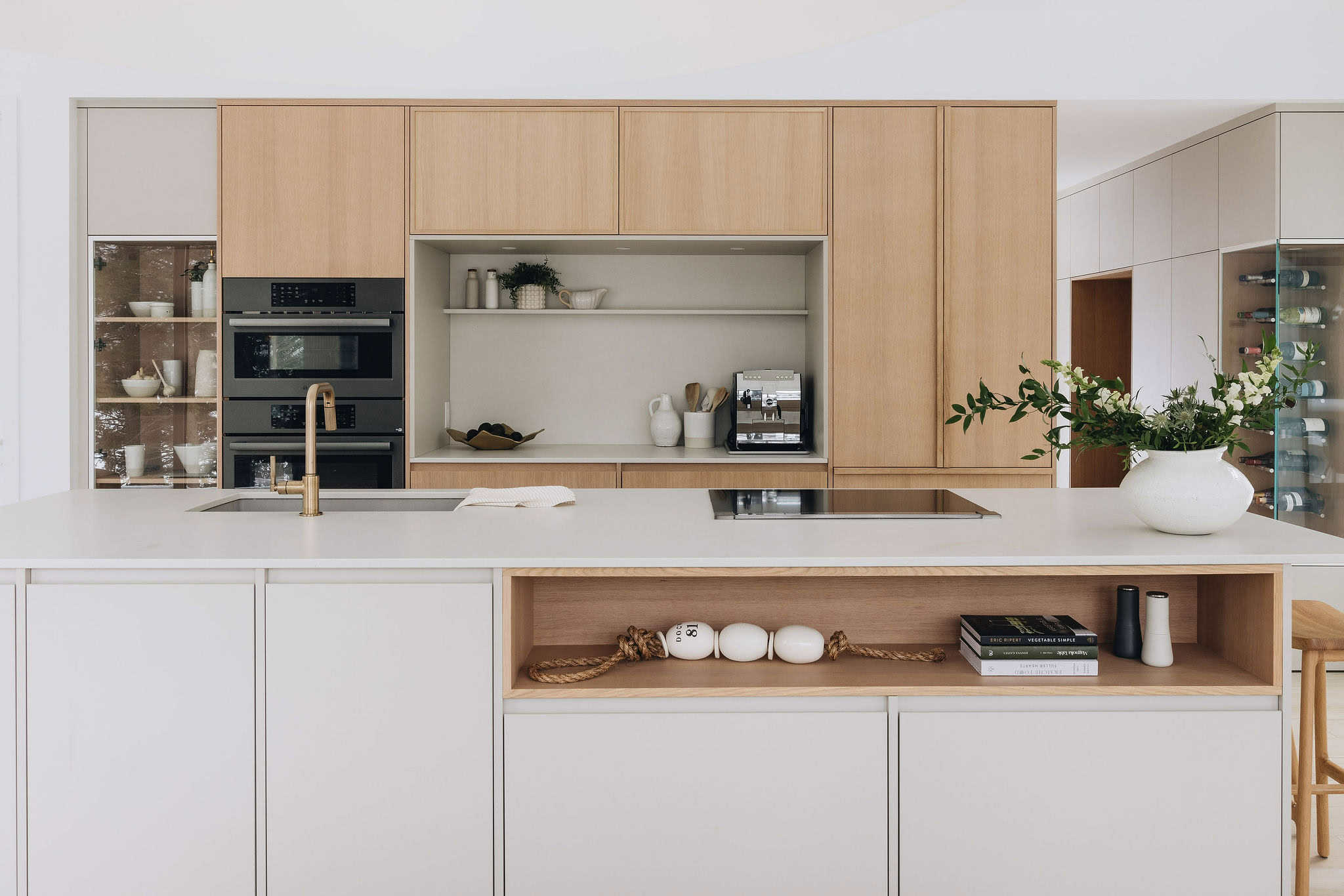 Cuisine minimaliste sur mesure avec armoires en bois clair et blanc mat, îlot central et design contemporain épuré