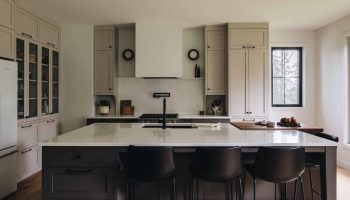 Cuisine transitionnelle sur mesure avec armoires grège, îlot central, bloc de boucher en noyer massif et design élégant