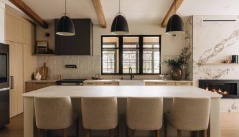 Cuisine chaleureuse sur mesure avec grand îlot aux coins arrondis, hotte rainurée, poutres apparentes et ambiance conviviale