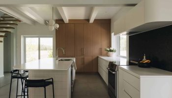 Cuisine élégante sur mesure avec îlot aux courbes douces, placage de chêne, comptoir mat et design contemporain raffiné