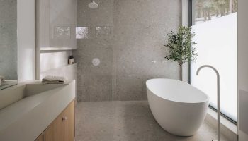 Salle de bain minimaliste sur mesure avec baignoire autoportante, surfaces en béton, meubles en bois clair et grande fenestration
