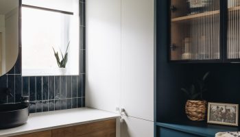 Salle de bain sur mesure avec vanité en bois, armoires bleues profondes, portes vitrées et design contemporain élégant