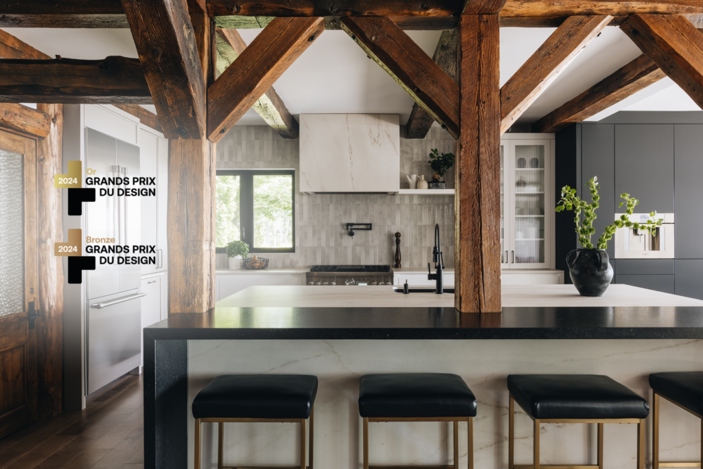 Cuisine sur mesure intemporelle avec poutres de bois apparentes, îlot central, matériaux modernes et ambiance chaleureuse